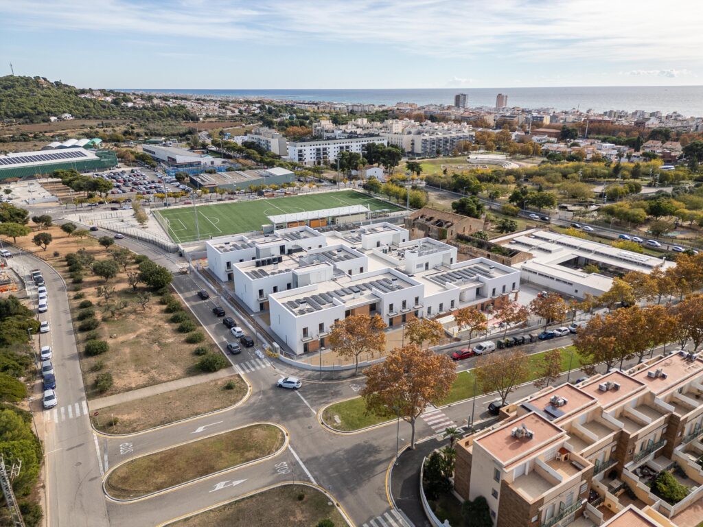 Vista aèria de la residència per a gent gran a Calafell, amb un edifici de baixa alçada organitzat en unitats de convivència i relacionat amb l’entorn urbà i el mar.