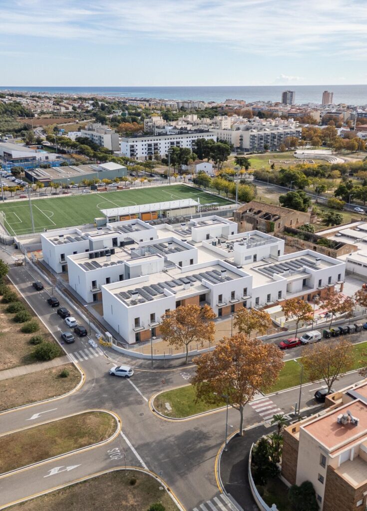 Vista aèria de la residència per a gent gran a Calafell, amb un edifici de baixa alçada organitzat en unitats de convivència i relacionat amb l’entorn urbà i el mar.